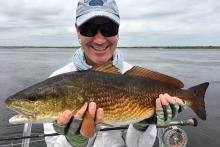 Global Environmental Health Sciences professor Chuck Miller holding a redfish.