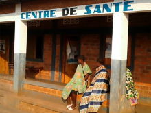 Two people sitting outside a health center in the DRC
