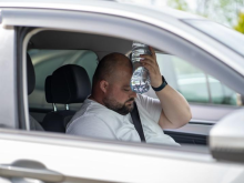 A man is stressed in the heat in his car