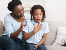 A child struggling with asthma in front of mother