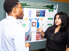 Two students discuss an AI poster presentation.