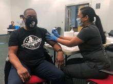 Thomas LaVeist in black shirt gets vaccinated.