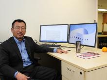 Dr. Lu Qi at desk with two monitors