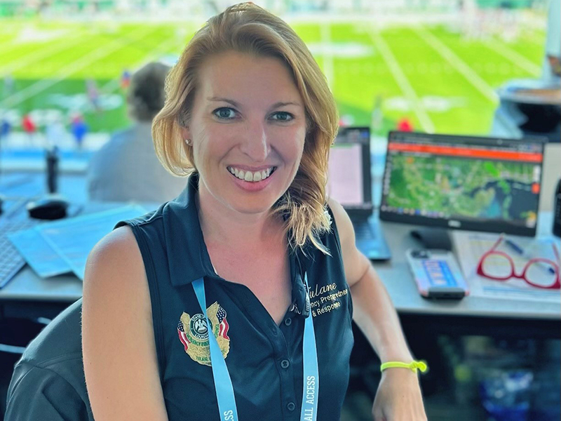 Meredith Beers, PhD, MPH sitting in a booth at a football game