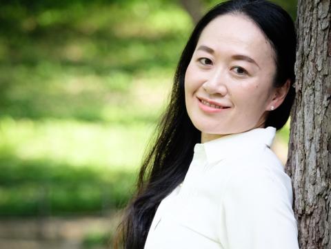 Rie Yotsu headshot, outdoors, leaning against a tree