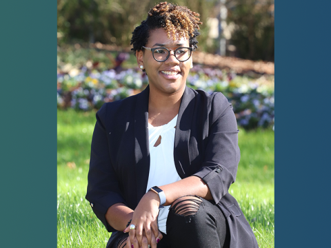 Chelsea Singleton, sitting, smiling, hands crossed