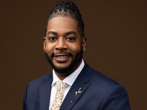 Rodney Anthony smiling at camera, wearing a suit