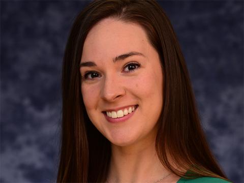 Headshot of Summyr Burton wearing green shirt and smiling.