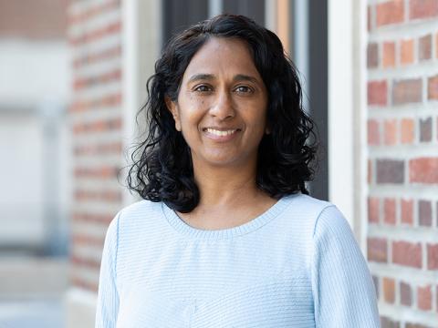 Shalini Kulasingam in a light blue top, posing for a headshot