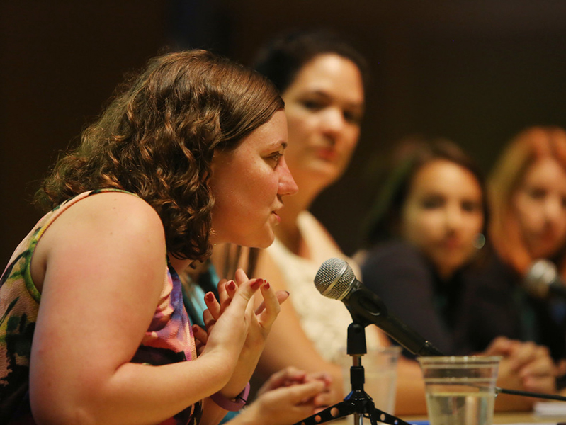 Woman on a panel of speakers talking into a microphone